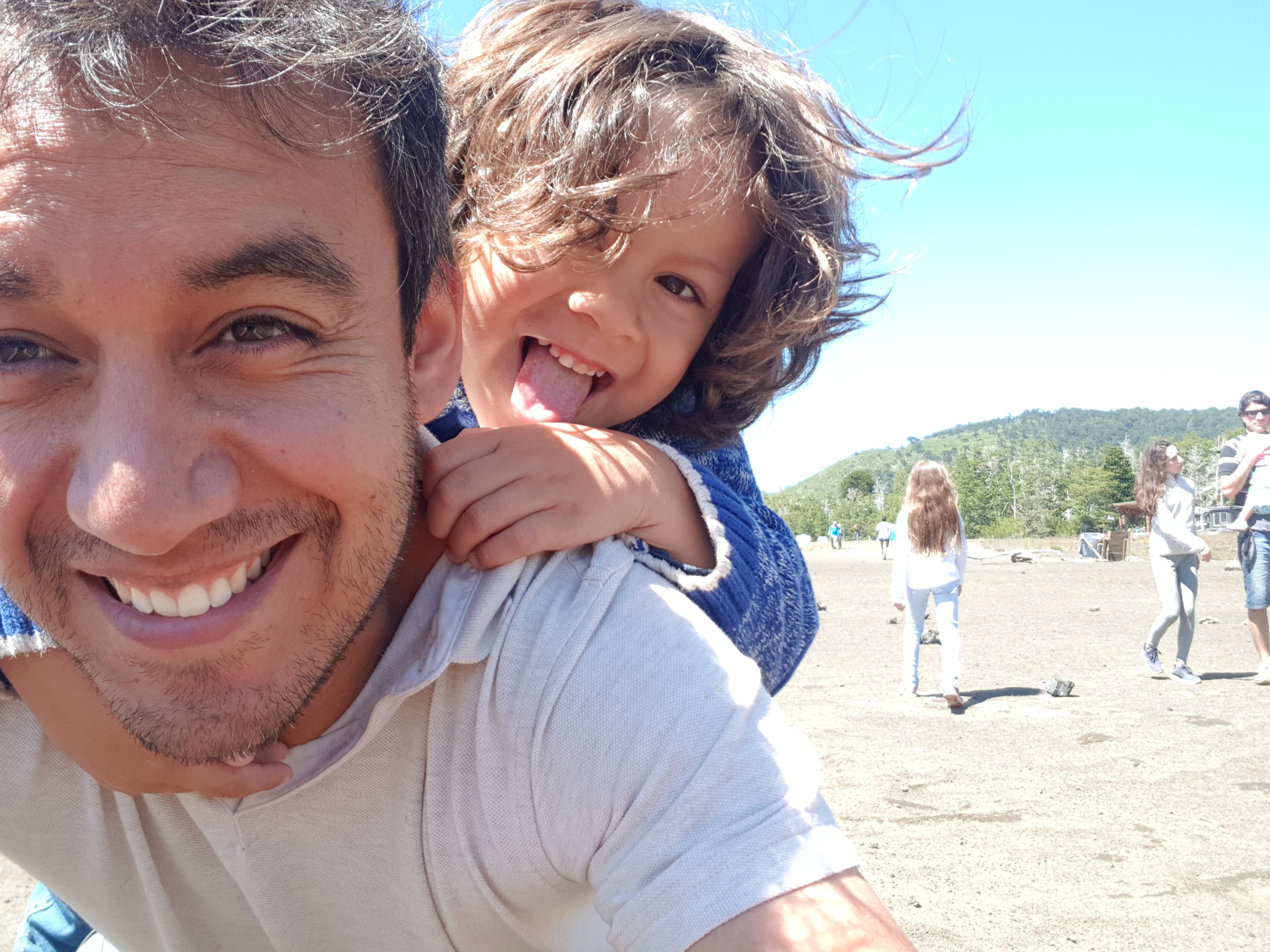 Clemente Alvarado Ríos at the beach with his son on a bright, sunny day